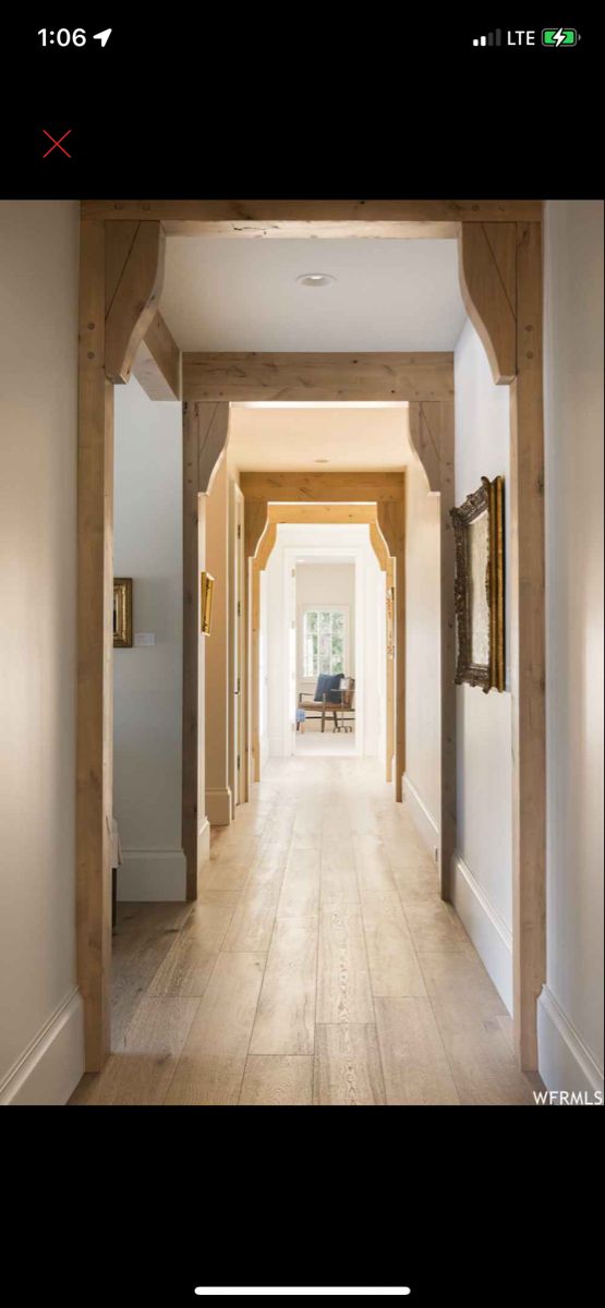 an open hallway with white walls and wood trim on the doors, leading to a sitting area