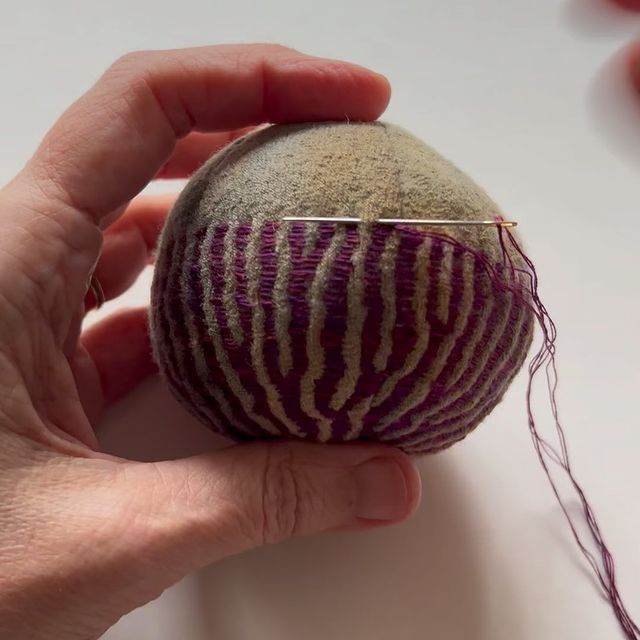 a person holding an object in their hand on a white surface with other items around it