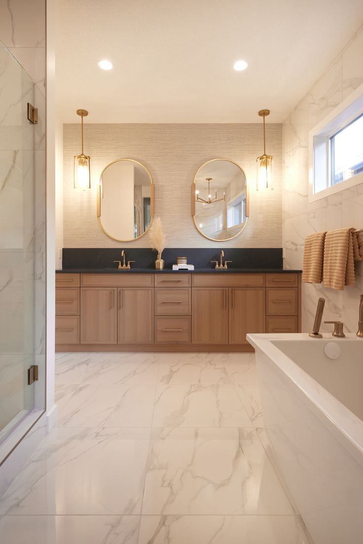 a large bathroom with marble floors and two round mirrors on the wall above the bathtub