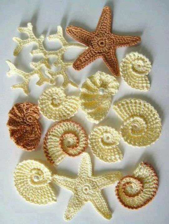 crocheted sea shells and starfishs are arranged on a white surface