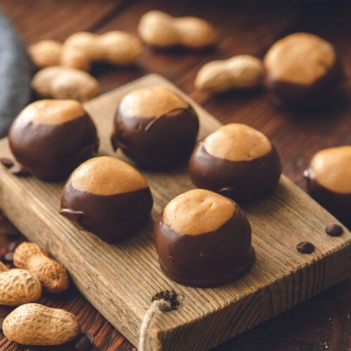 chocolates and peanuts on a wooden cutting board