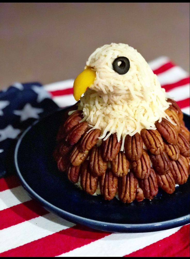 a plate that has some kind of food on it with an eagle head made out of pecans