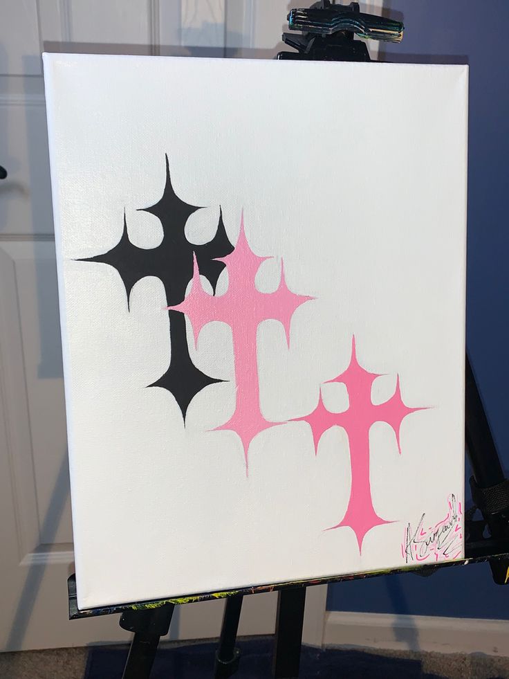 a white canvas with pink and black designs on it sitting in front of a door