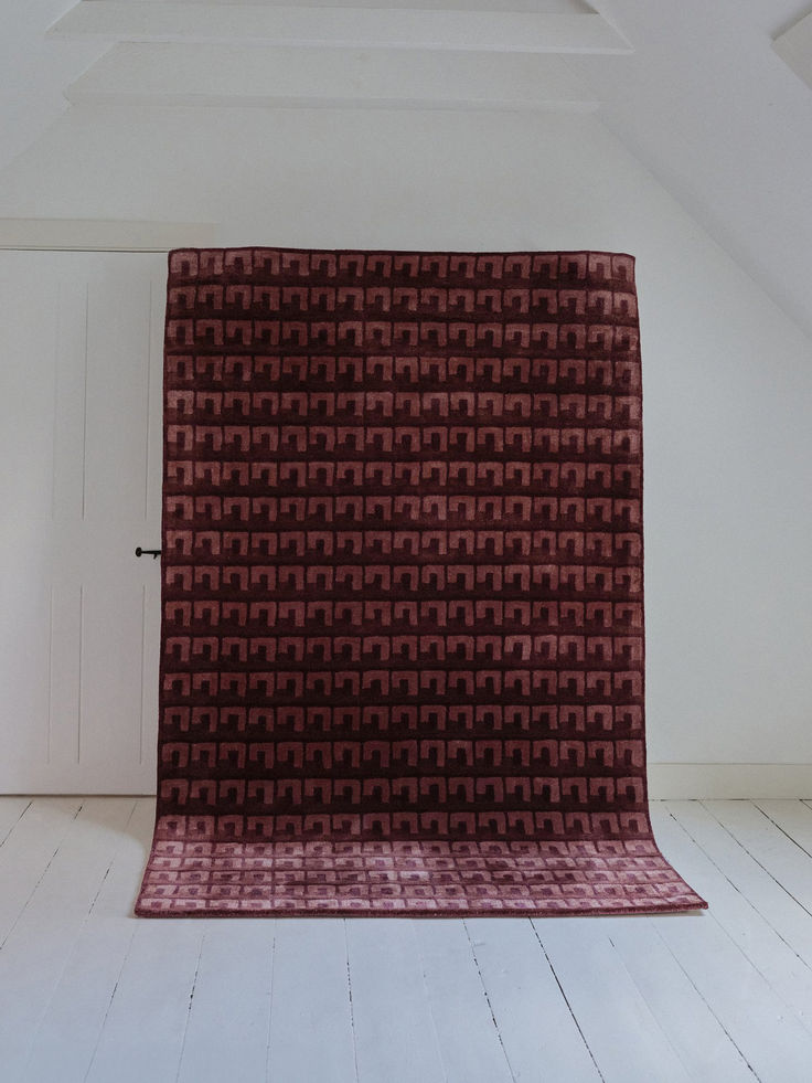 an empty room with a red rug on the floor