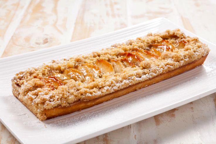 a white plate topped with a pastry on top of a wooden table