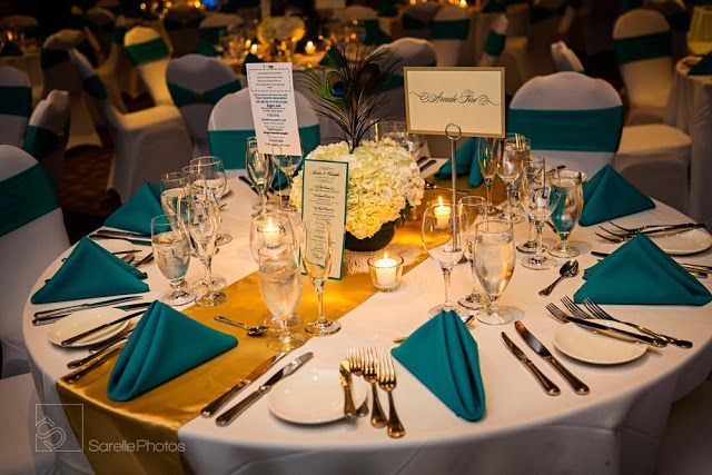 the table is set with silverware and blue napkins for an elegant wedding reception