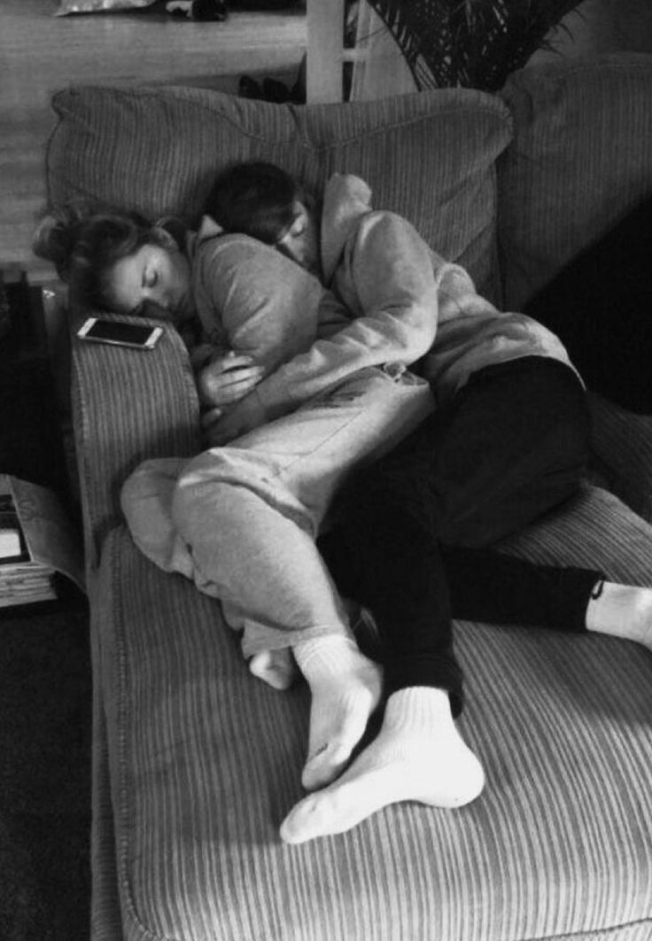 black and white photograph of two people sleeping on a couch