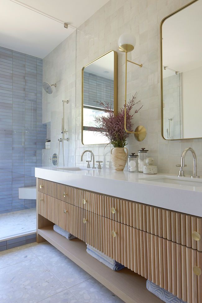 a large bathroom with two sinks and mirrors on the wall next to it's walk - in shower