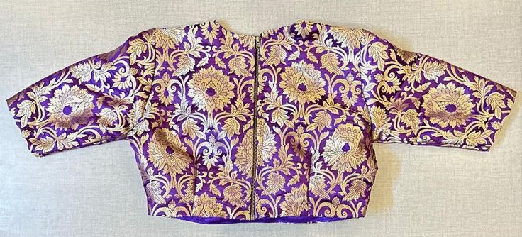 Beautiful purple Banarasi saree blouse. Buy designer blouse in USA from Pure Elegance. Disclaimer: The actual product may vary slightly from the image. These are custom orders, hence expect slight variation in color, placement of the motif or buta. ESTIMATED DELIVERYBecause this is a custom order, it would take about 4 weeks from the date of purchase. RETURN POLICY: This product is a custom order and cannot be returned or exchanged. Purple Banarasi Saree, Banarasi Saree Blouse, Designer Saree Blouse, Saree Blouses Online, Indian Clothing Store, Blouse Designer, Corset Blouse, Saree Style, Readymade Saree