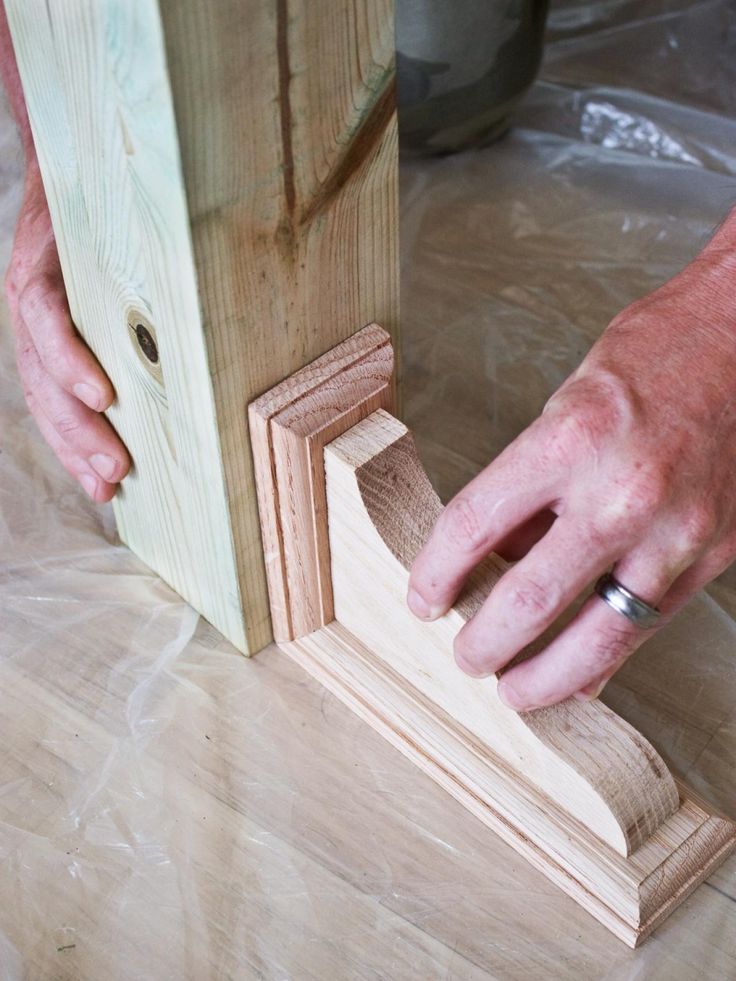 a person is working on some wood with their hand and the other hand holding it