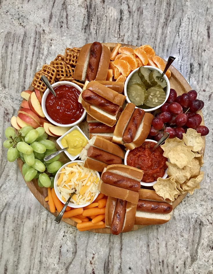 a platter filled with hot dogs and other foods