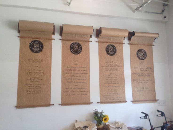 three wooden banners hanging on the wall above a table with flowers and other items in front of it