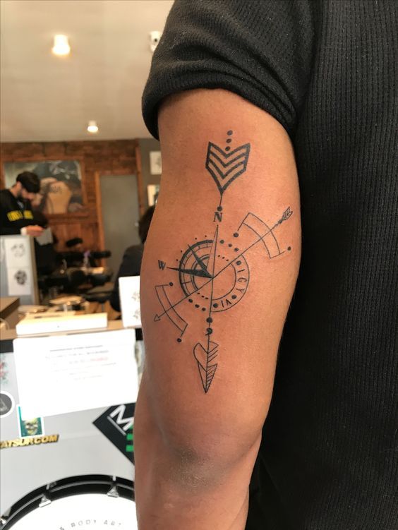 a man with a compass tattoo on his arm