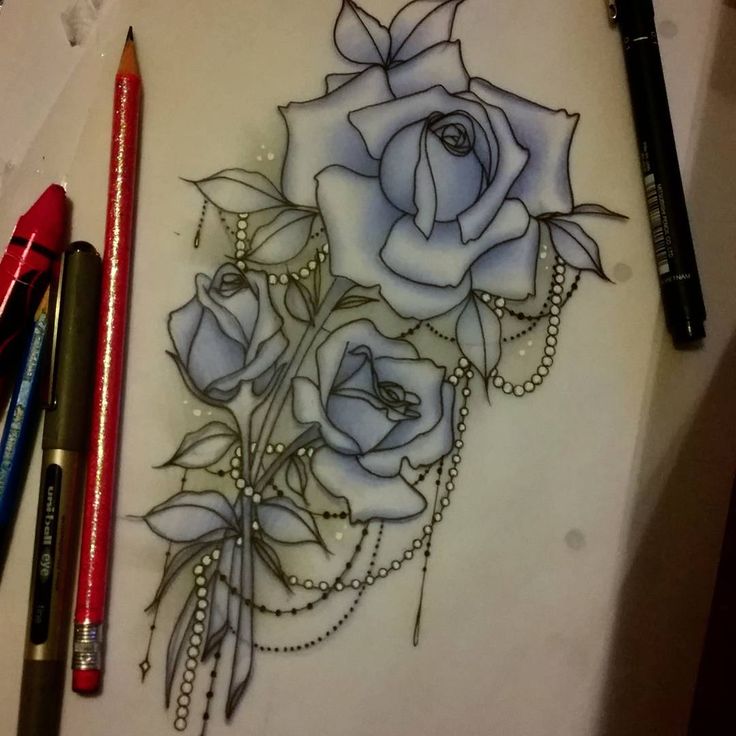 a drawing of a rose with pearls on it and some beads around the neck, next to two crayons