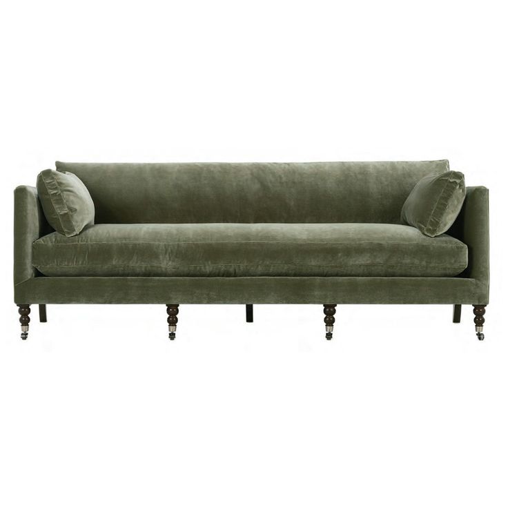 a green velvet couch with two pillows on it's arms and legs, against a white background