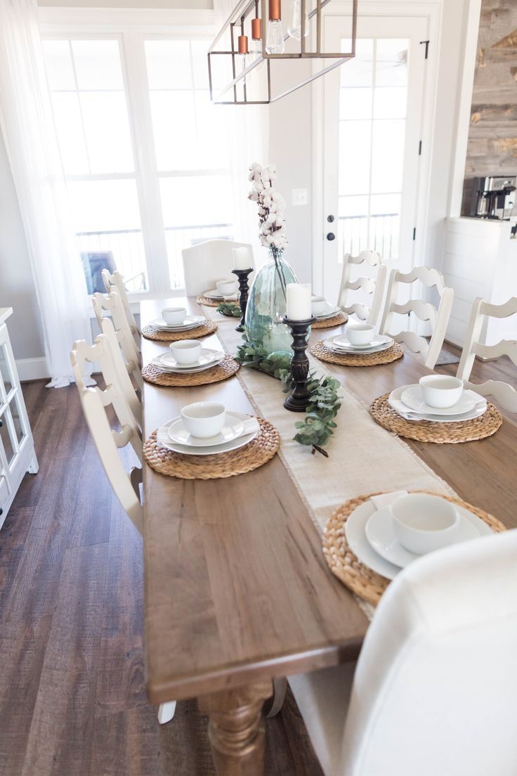 the dining room table is set with white plates and place settings for four people to sit at