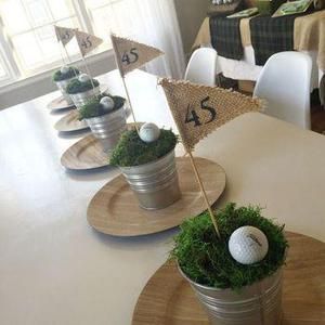 the table is set up with golf balls and grass in buckets for centerpieces