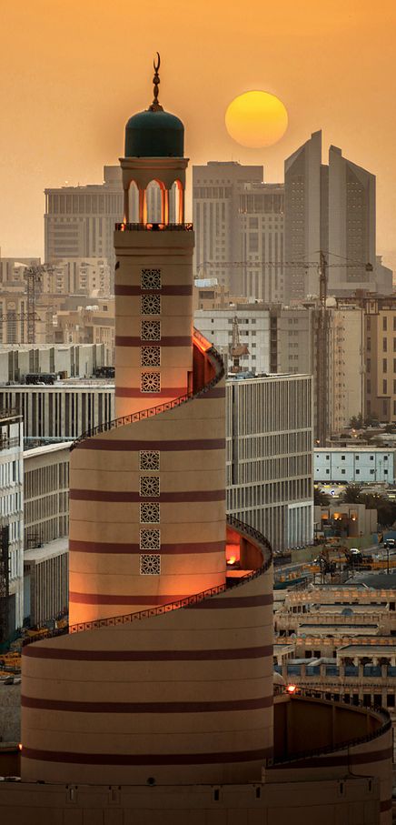 a tall tower with a clock on it's side in the middle of a city