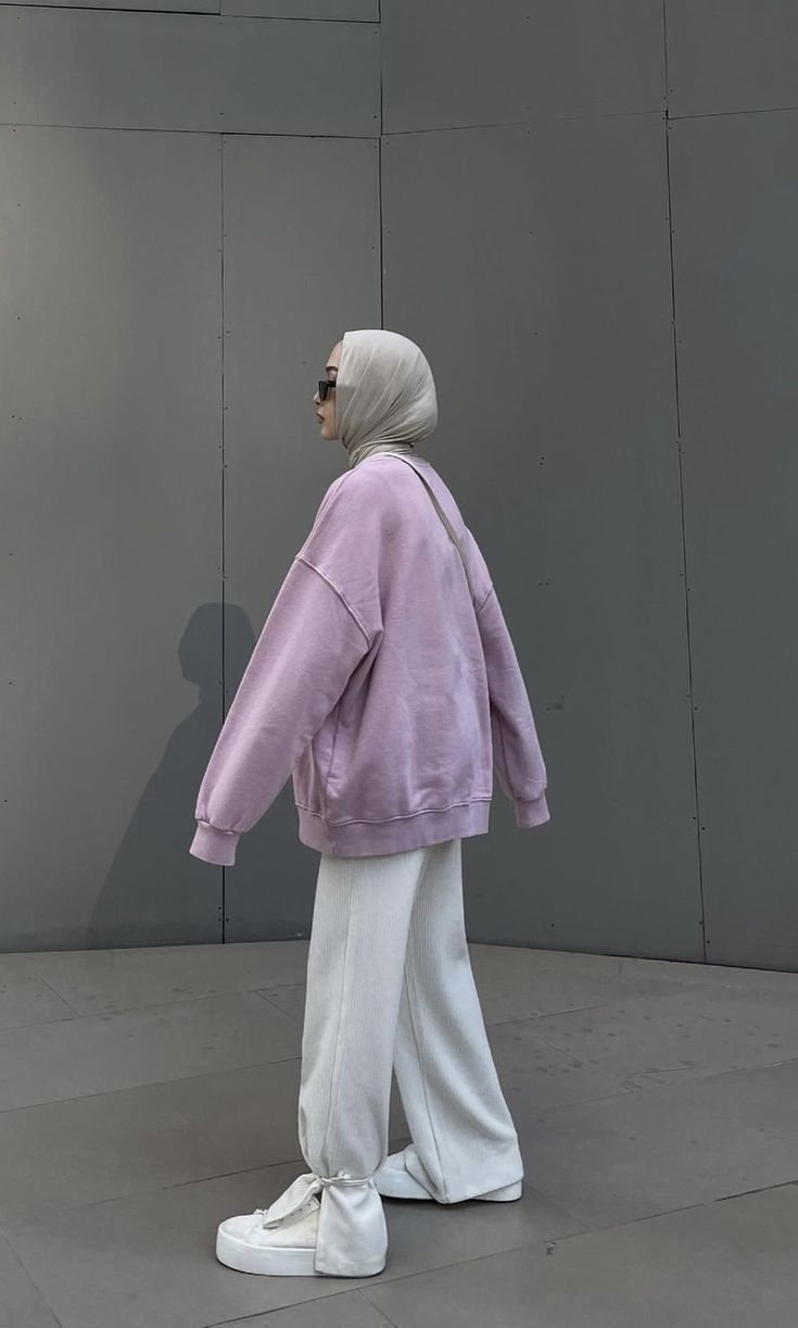 a woman in purple jacket and white pants