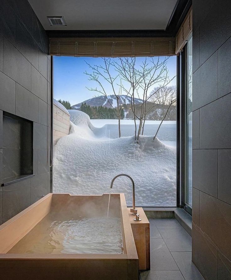 a large bath tub sitting in the middle of a bathroom next to a sliding glass door