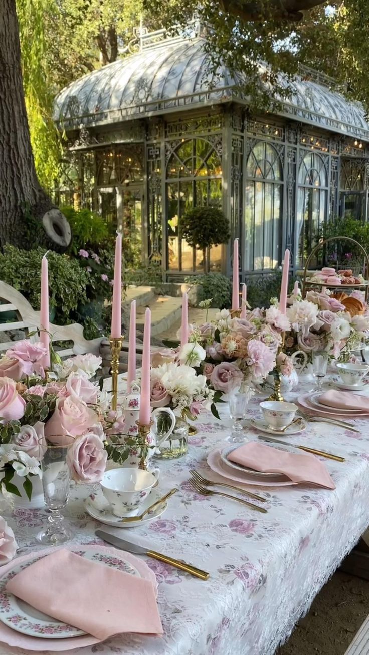 a long table with pink and white flowers on it is set for a formal dinner