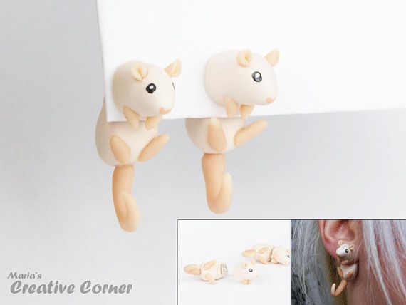 a pair of earrings that are shaped like sheeps hanging from the side of a wall