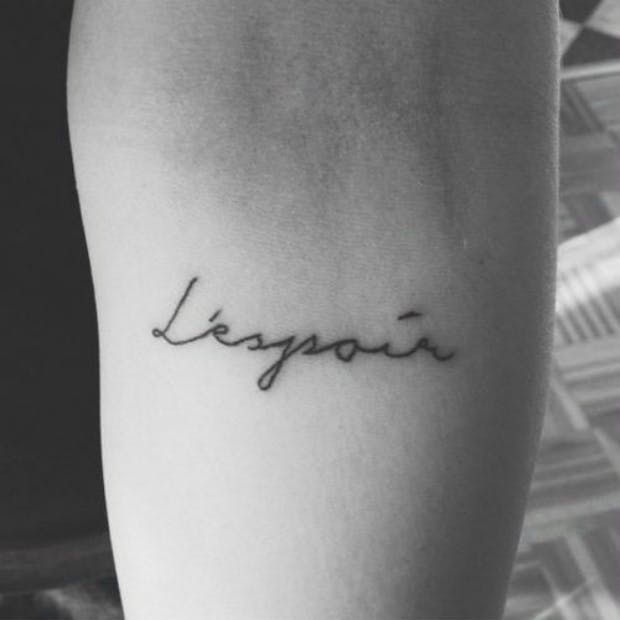 a small tattoo on the arm that says,'lygou'in cursive writing