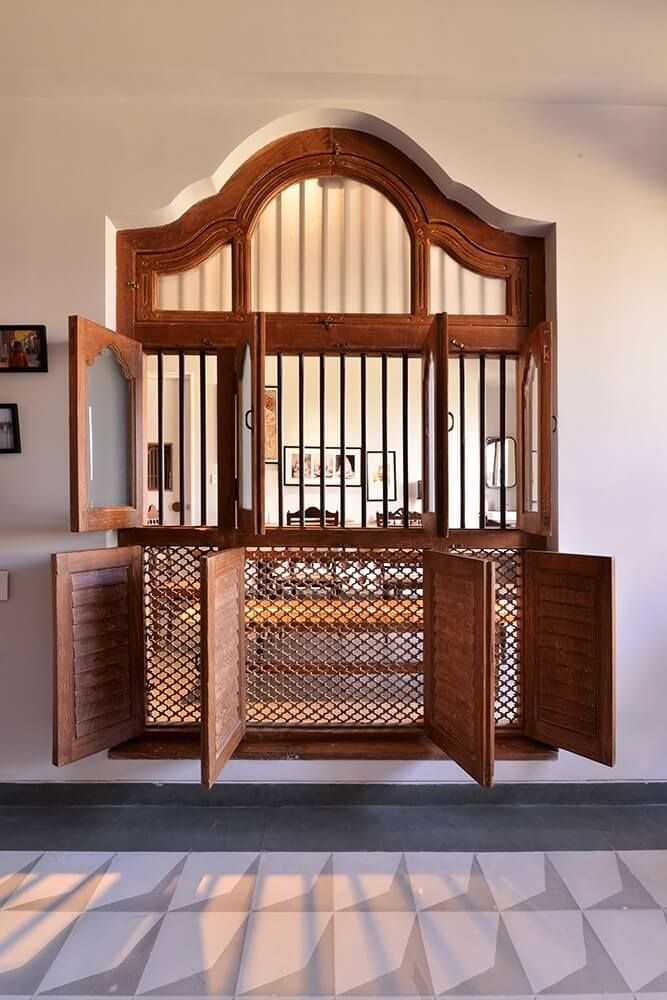 an open wooden door in the middle of a room with tile flooring and walls