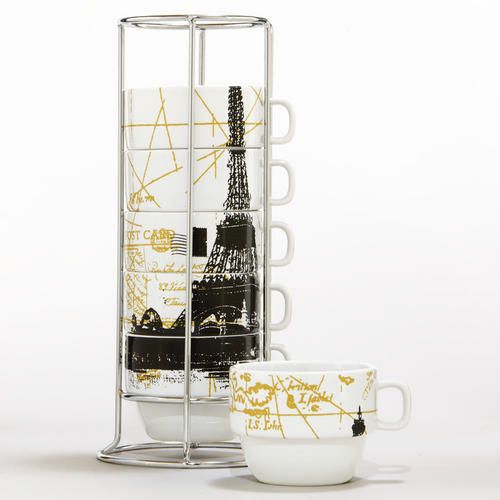 two mugs are sitting next to each other in front of a rack with the eiffel tower on it