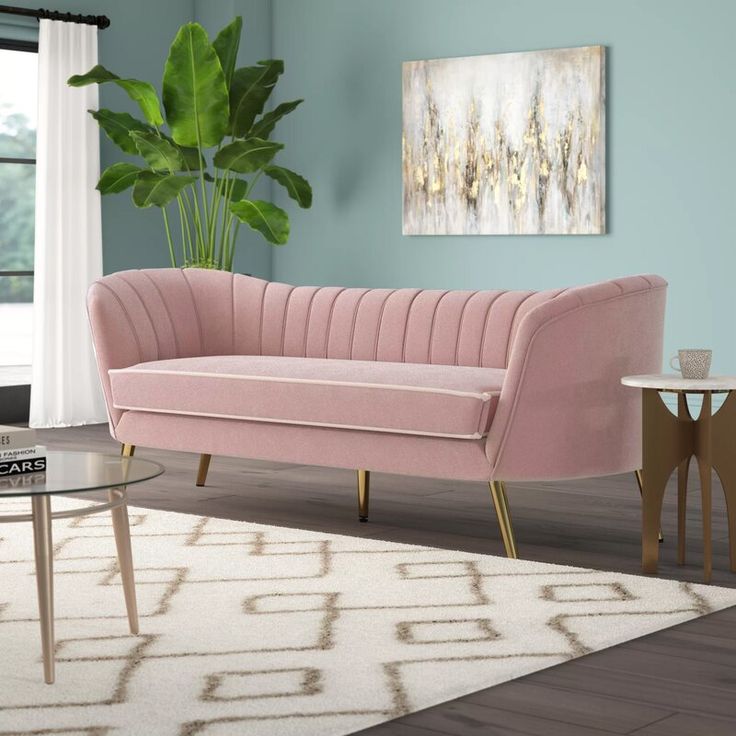 a living room with a pink couch and coffee table