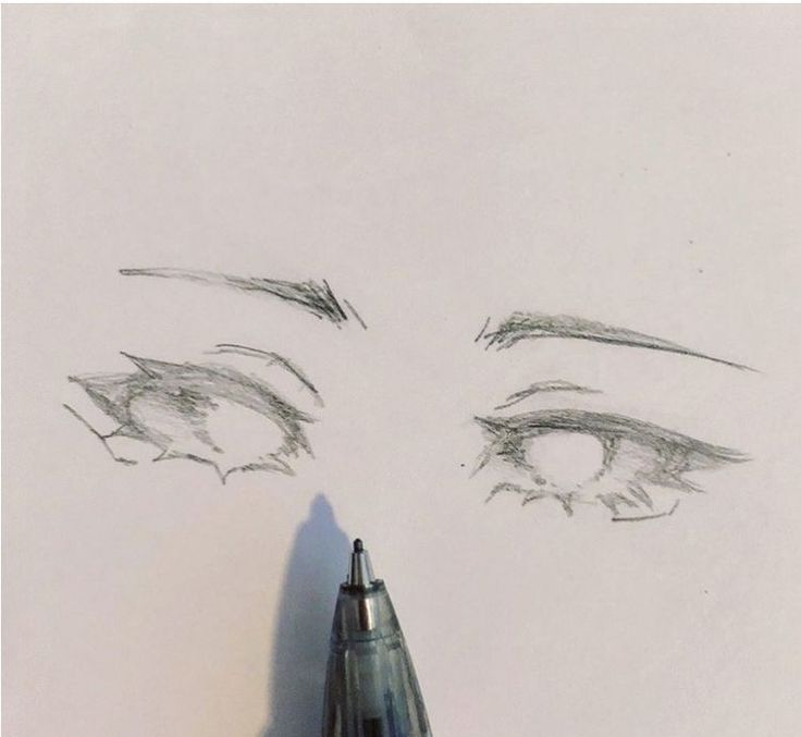 the eye is drawn on paper with a pen and it's tip sticking out