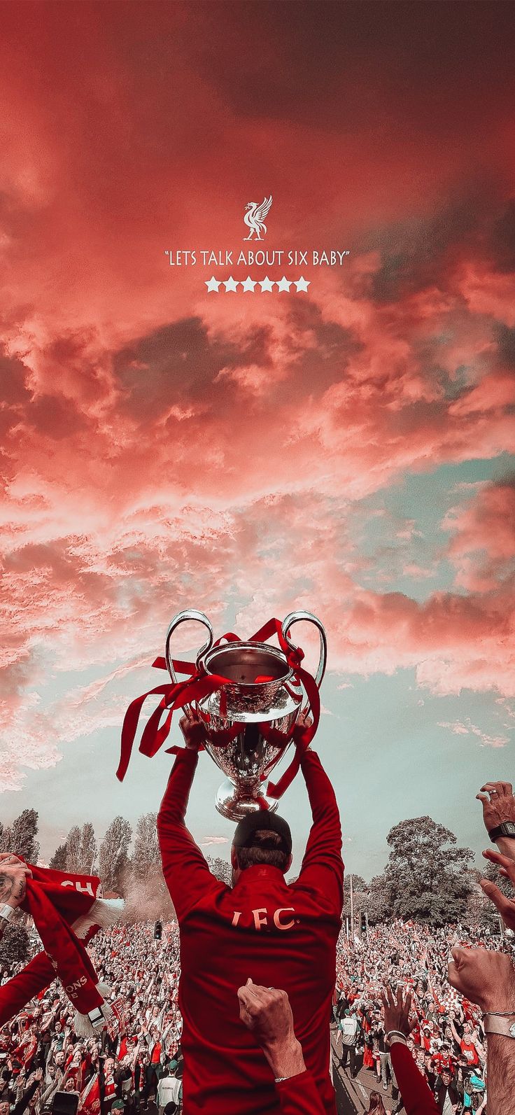 a man holding up a silver trophy in front of a red and white sky with clouds