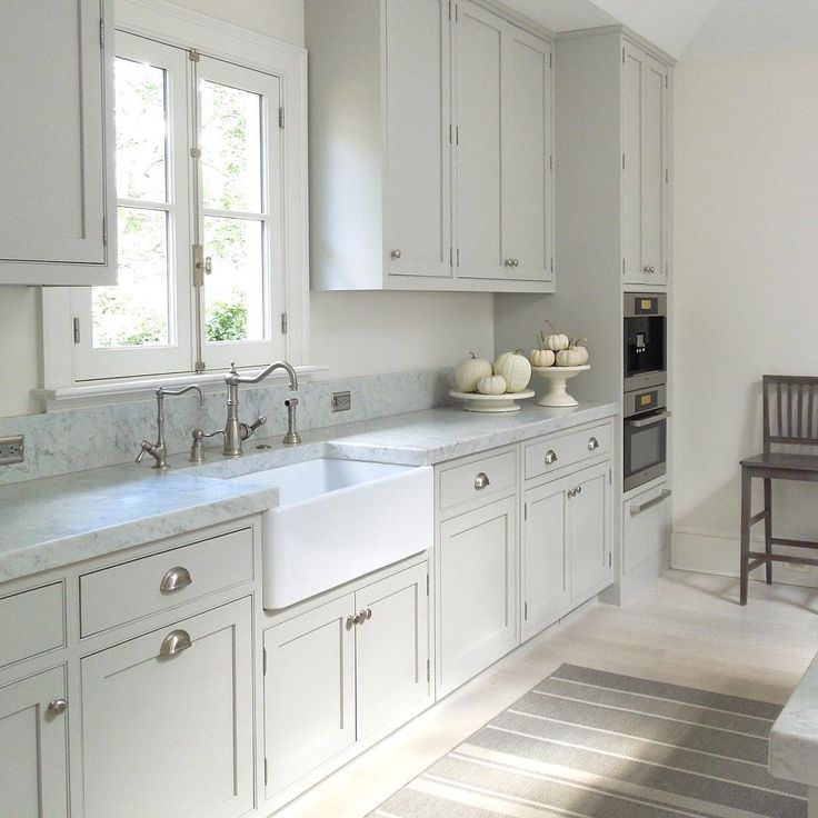 an image of a kitchen with white cabinets and gray flooring on the bottom right hand corner