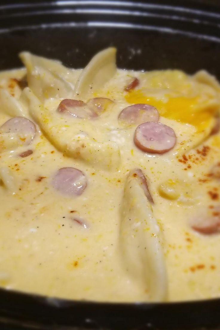 pasta with ham and cheese in a black bowl