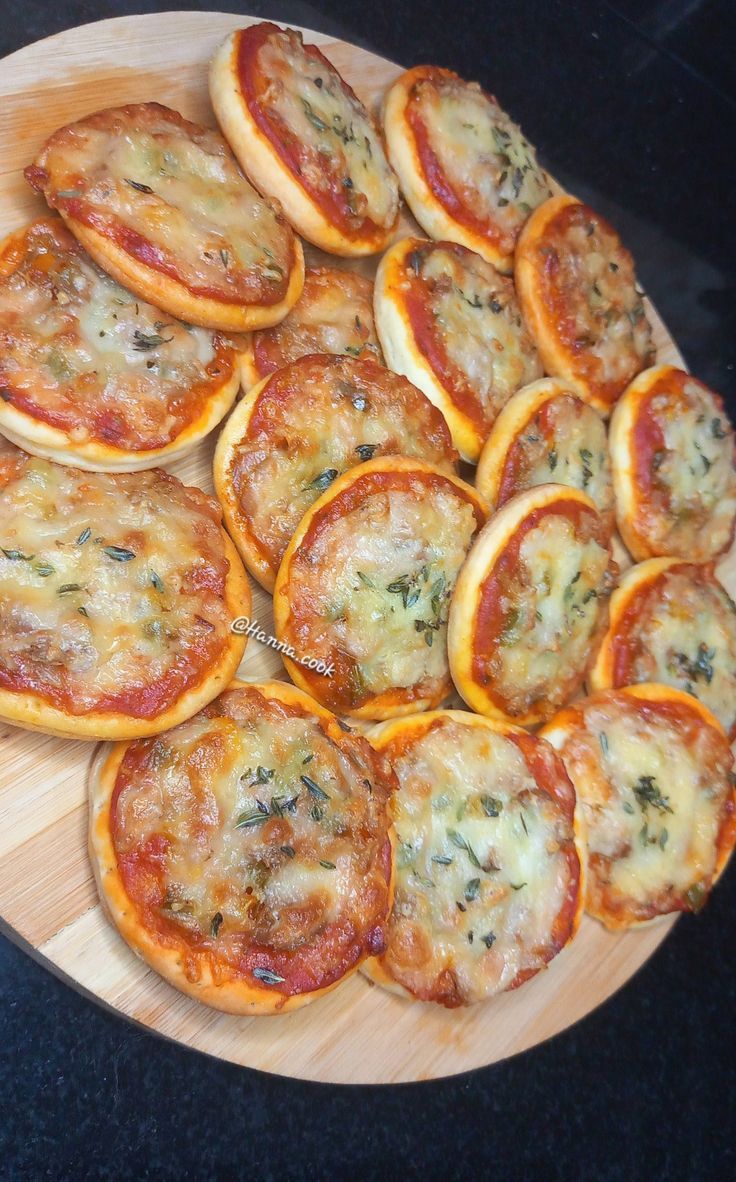 small pizzas are arranged on a wooden platter