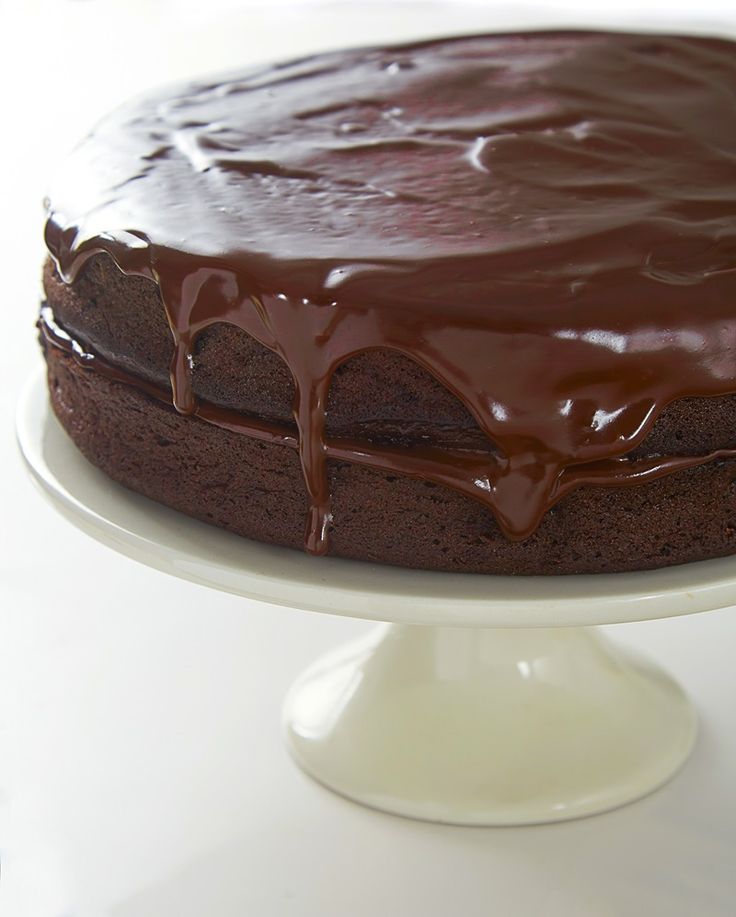 a chocolate cake is sitting on a white plate