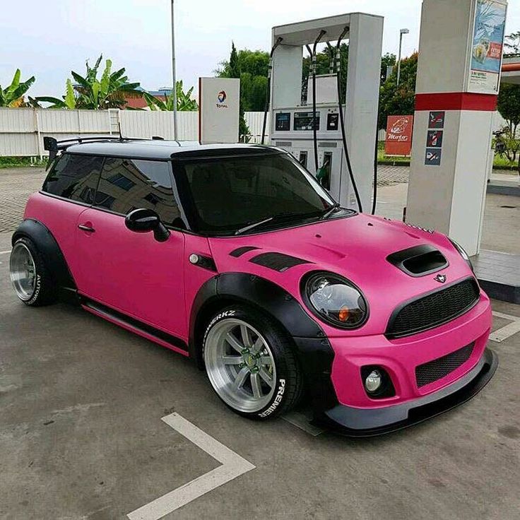 a pink and black car parked at a gas station