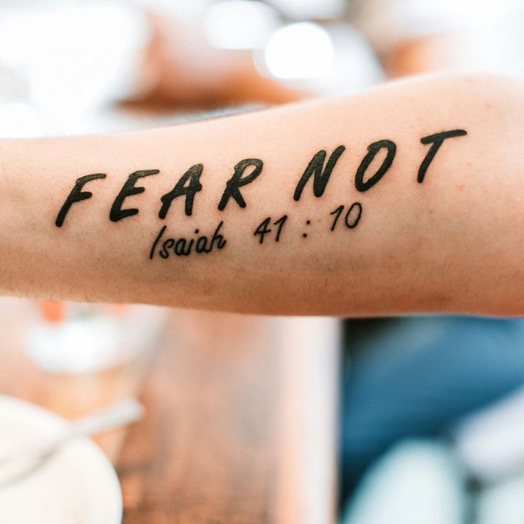 a person's arm with the word fear not written in black ink on it