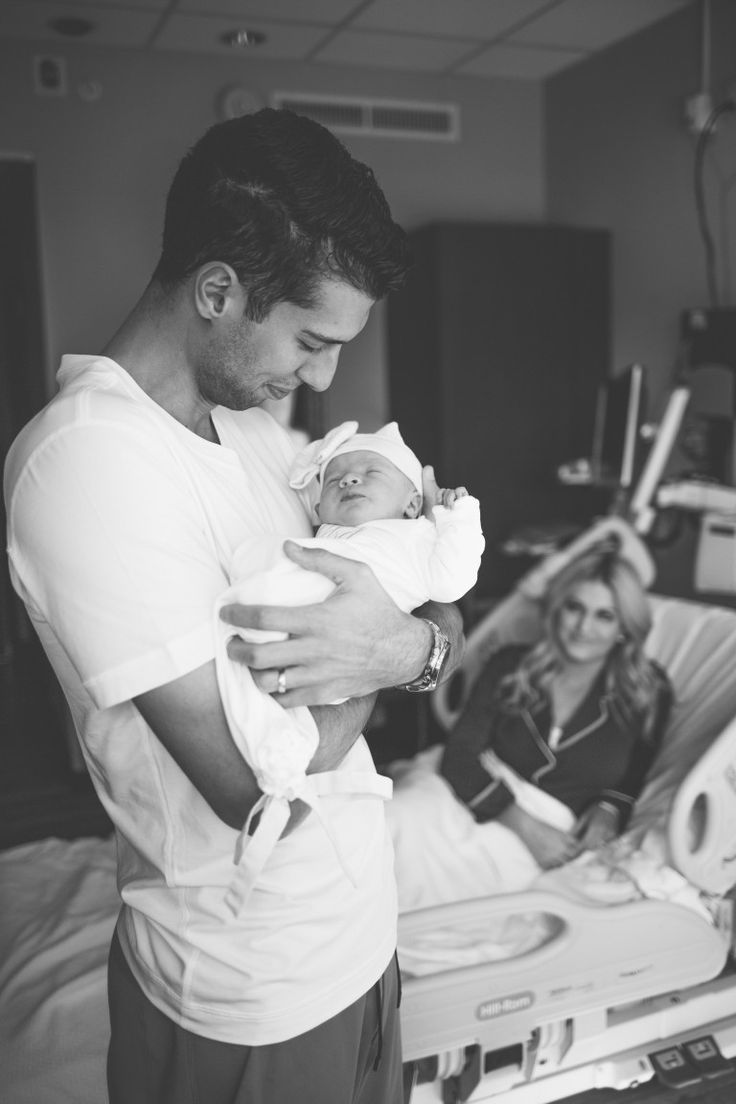 a man holding a baby in a hospital bed