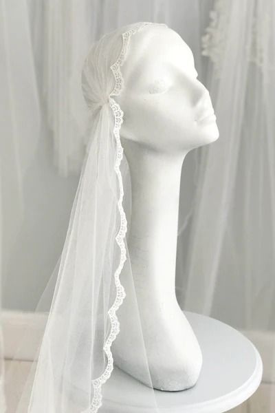 a white mannequin with a veil on top of it