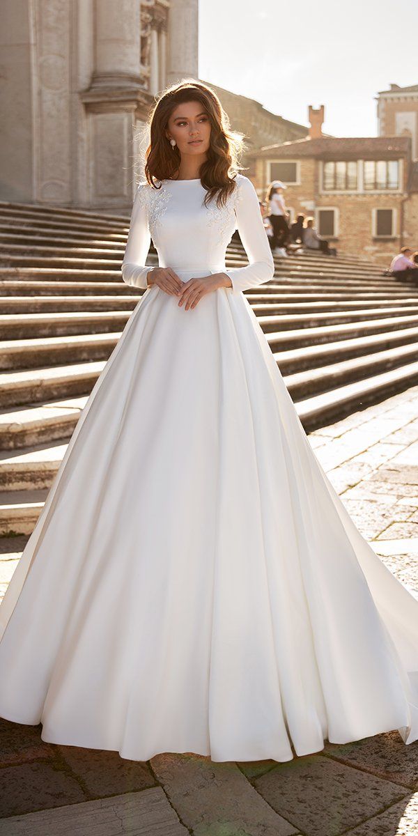 a woman in a white wedding dress standing on steps