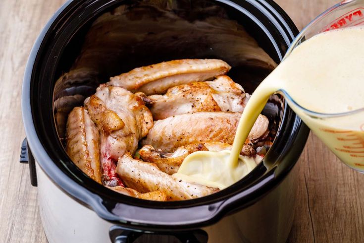 the chicken is being poured into the slow cooker to make it easier for them to cook