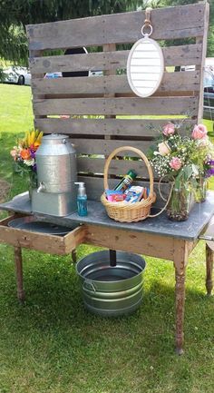 a bench made out of an old pallet with flowers and watering cans on it