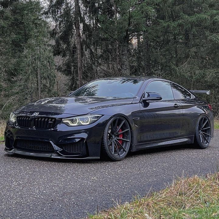 a black bmw is parked on the side of the road