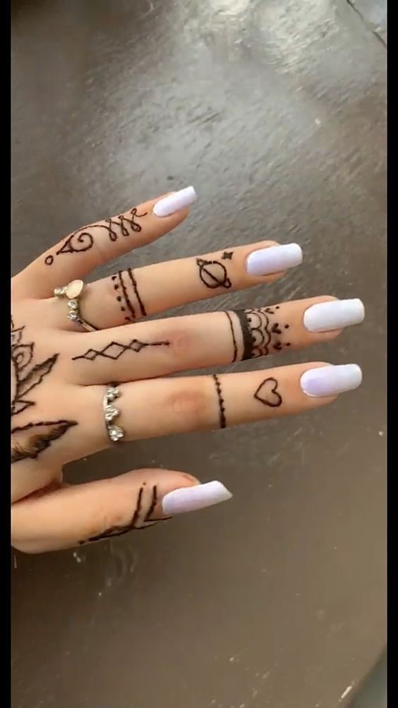 a woman's hand with henna tattoos on it