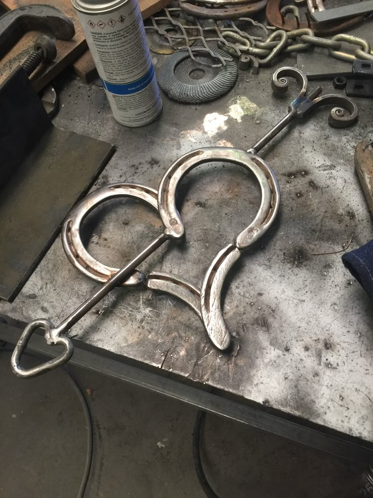 a metal object sitting on top of a table next to other tools and materials in the background