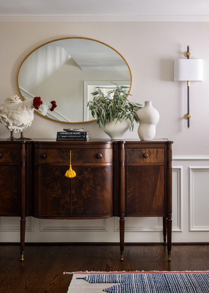 a wooden dresser sitting in front of a mirror on top of a hard wood floor