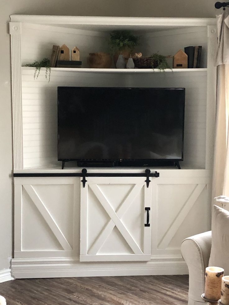 an entertainment center with sliding doors and a flat screen tv mounted on it's wall