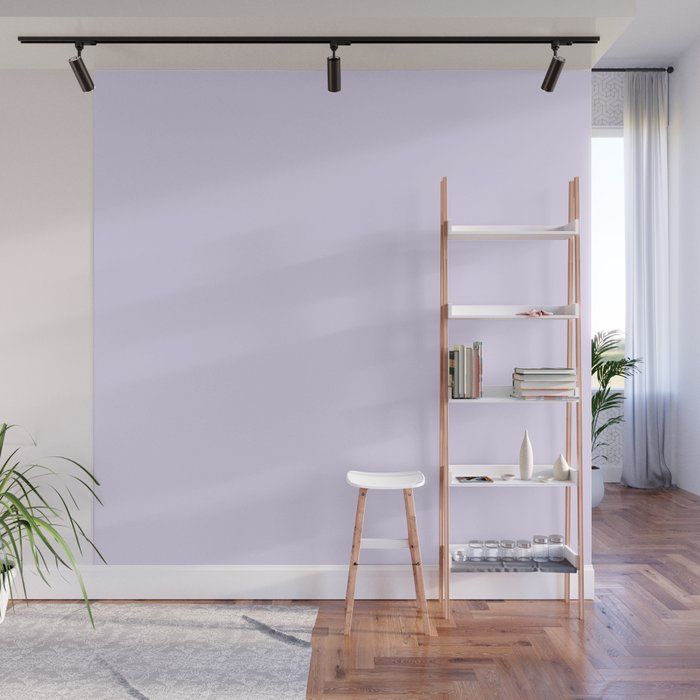 a living room with purple walls and white furniture in the corner, there is a plant next to it