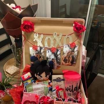 an open suitcase filled with personal items and gifts for someone's birthday or valentine's day